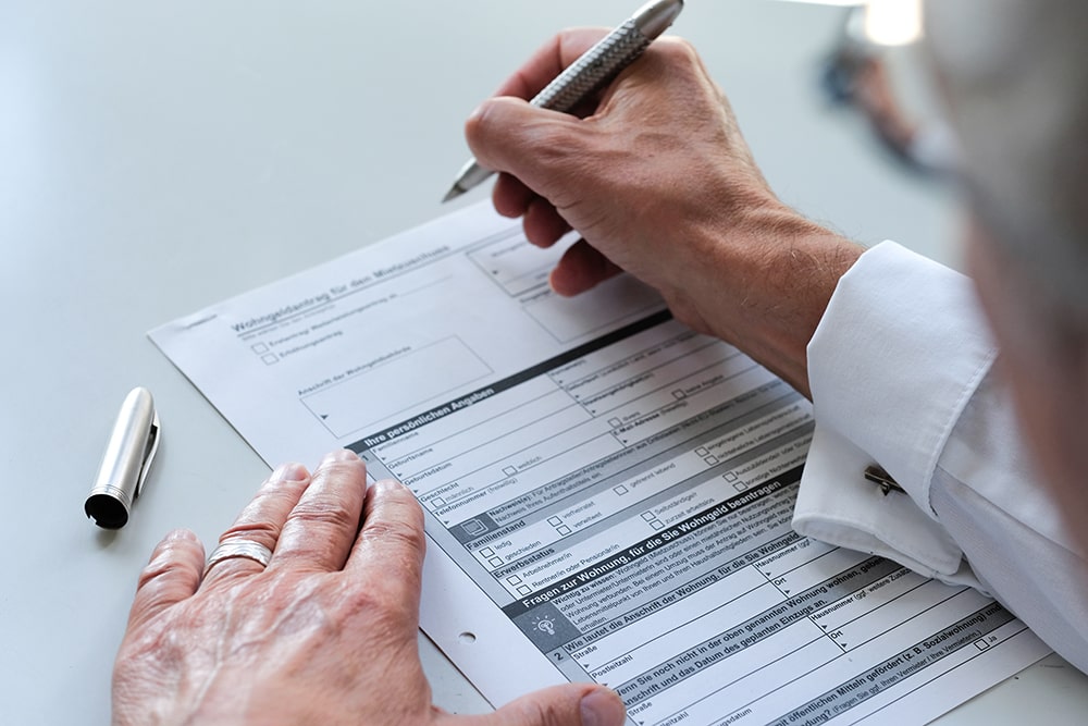 wohngeld-formular1 Wohngeld Formular liegt auf einem Schreibtisch und wird ausgefüllt