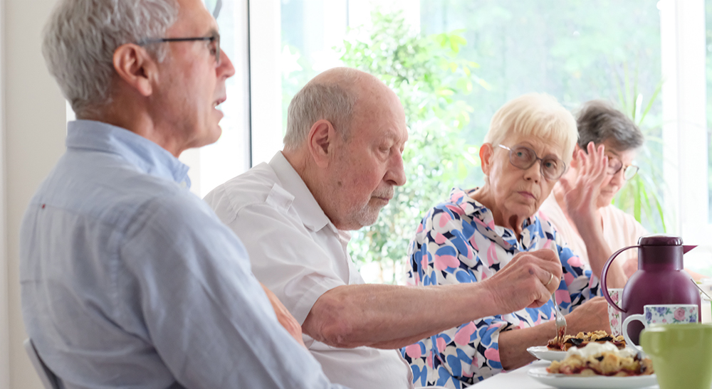 wohngeld-fuer-rentner2 Wohngeld für Rentner: Wohngeld-Berater sitzt mit einer Gruppe Rentnern an einem Tisch