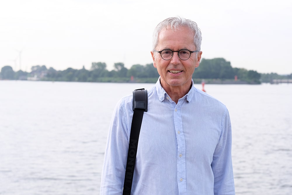 Wohngeld Berater steht vor der Elbe und bietet seine Wohngeld Hilfe in Hamburg an